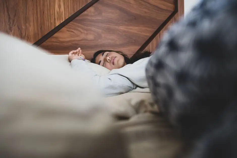 Chambre à coucher aux draps froissés, ventilateur en marche et lumière bleutée de nuit chaude